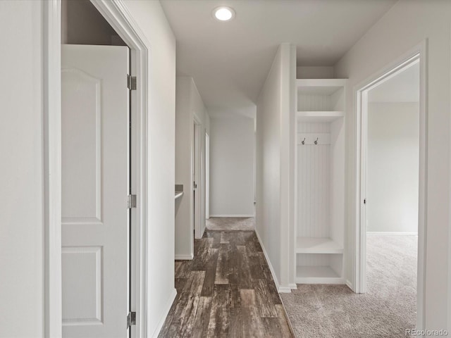 hall featuring dark colored carpet