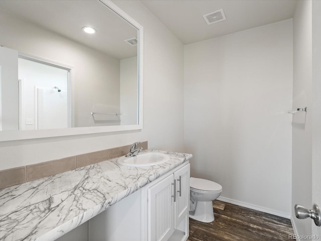 bathroom with vanity, toilet, and hardwood / wood-style floors