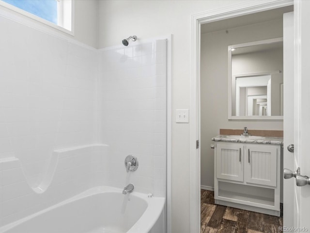 bathroom featuring hardwood / wood-style floors, oversized vanity, and shower / bathtub combination