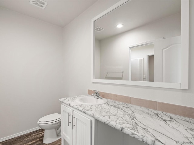 bathroom with hardwood / wood-style floors, toilet, and vanity