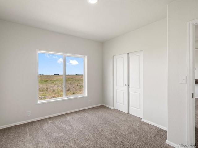 unfurnished bedroom featuring carpet flooring and a closet