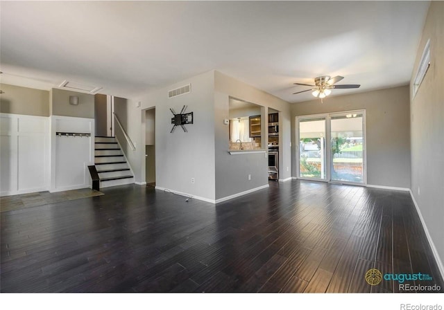 unfurnished living room with visible vents, baseboards, a sink, a ceiling fan, and wood finished floors