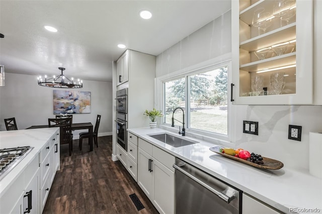 kitchen featuring white cabinetry, dishwasher, sink, an inviting chandelier, and dark hardwood / wood-style floors