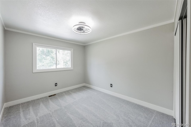 spare room featuring light colored carpet and ornamental molding