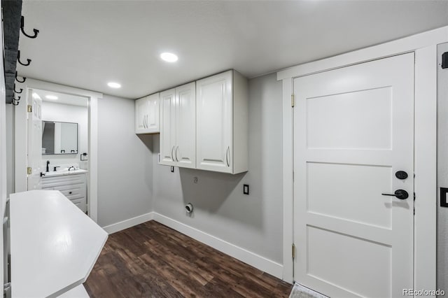 laundry area with electric dryer hookup, cabinets, and dark hardwood / wood-style floors