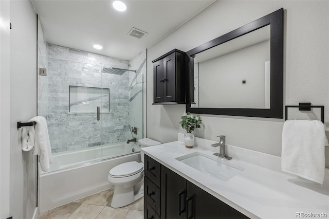 full bathroom with tile patterned floors, vanity, toilet, and bath / shower combo with glass door