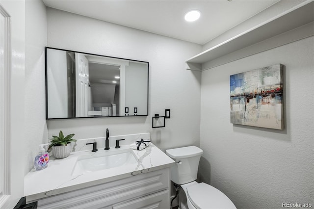 bathroom featuring vanity and toilet