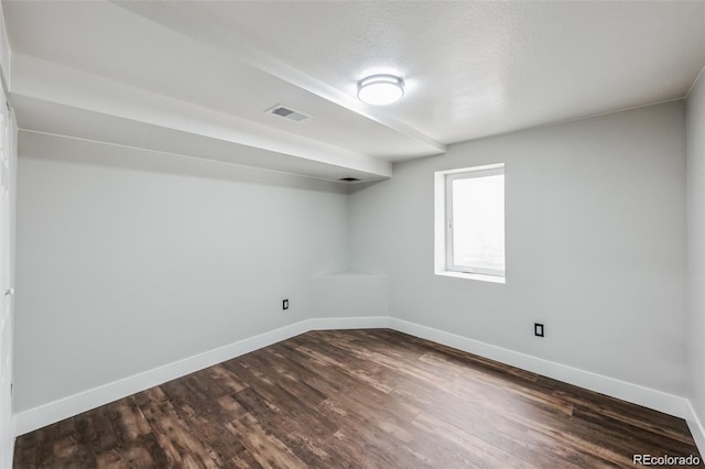 unfurnished room with a textured ceiling and dark hardwood / wood-style flooring