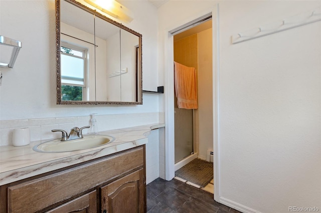 bathroom with a shower with door, backsplash, and vanity