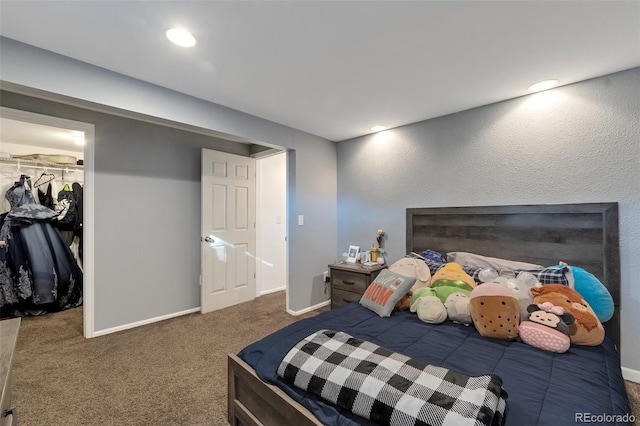 bedroom with a closet, carpet, and a spacious closet