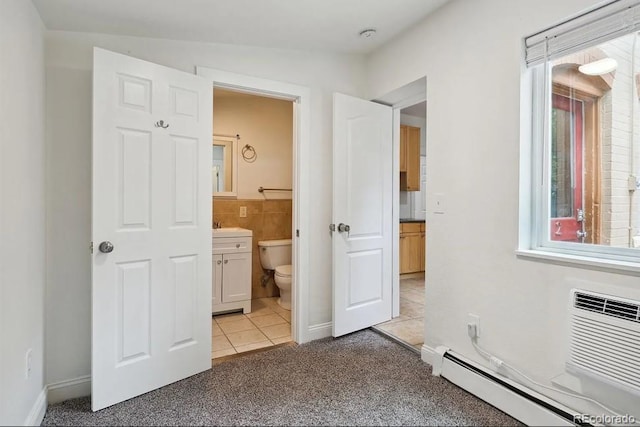 1037 12th St, Boulder, CO 80204 - unfurnished bedroom with a baseboard radiator, light tile patterned floors, light colored carpet, connected bathroom, and an AC wall unit