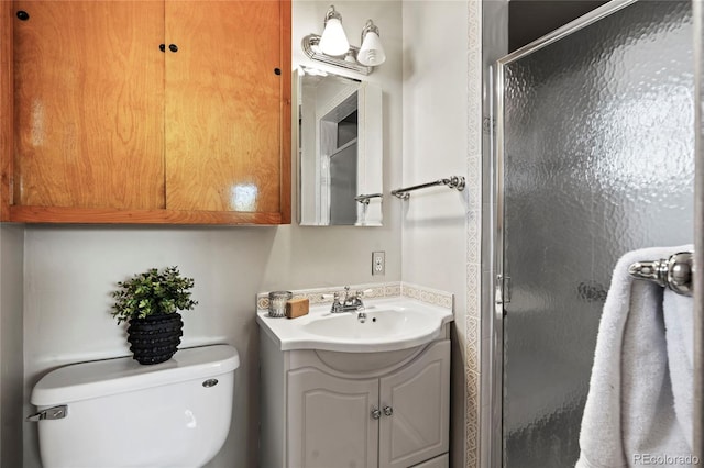 bathroom featuring vanity, an enclosed shower, and toilet