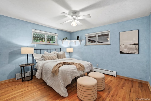 bedroom featuring hardwood / wood-style flooring, ceiling fan, and baseboard heating