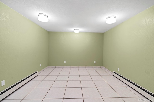 tiled empty room with a baseboard radiator and a textured ceiling