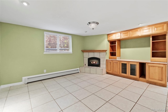 unfurnished living room featuring a tiled fireplace, a baseboard radiator, and light tile patterned flooring