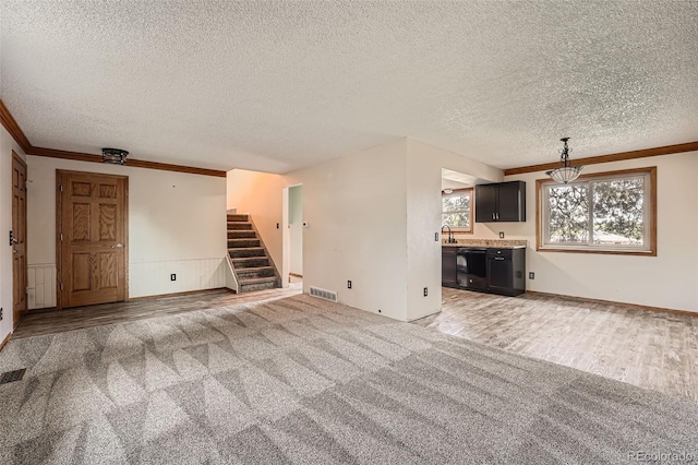 1824 S Granby St, Aurora, CO 80012 - unfurnished living room with a textured ceiling, stairway, crown molding, light wood-type flooring, and a sink