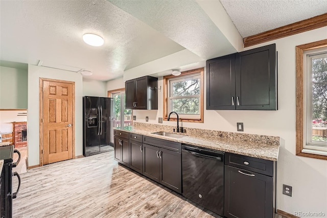 1824 S Granby St, Aurora, CO 80012 - kitchen featuring black appliances, a sink, a textured ceiling, light wood-style flooring, and light stone counters