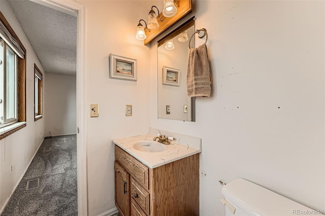 1824 S Granby St, Aurora, CO 80012 - half bathroom with vanity, toilet, a textured ceiling, plenty of natural light, and baseboards