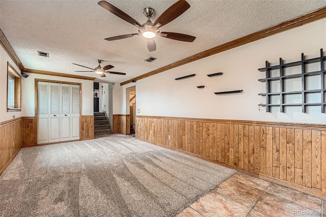 1824 S Granby St, Aurora, CO 80012 - unfurnished bedroom featuring a wainscoted wall, wood walls, crown molding, a textured ceiling, and a closet