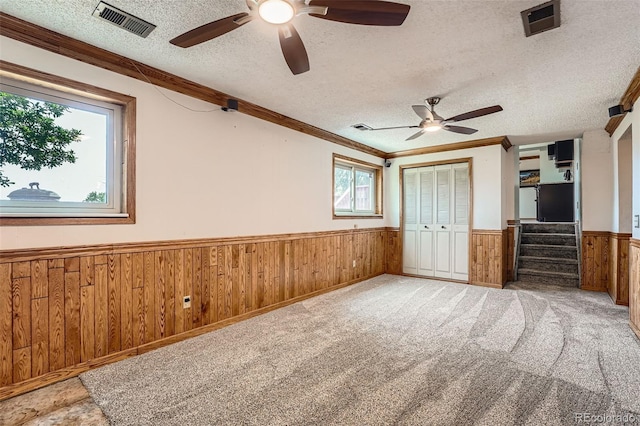 1824 S Granby St, Aurora, CO 80012 - unfurnished bedroom featuring wainscoting, wooden walls, a textured ceiling, ornamental molding, and a closet