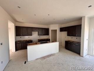 kitchen featuring a center island and dark brown cabinets