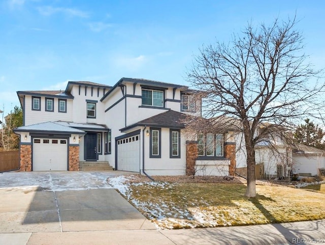 prairie-style house with a garage, driveway, and stucco siding