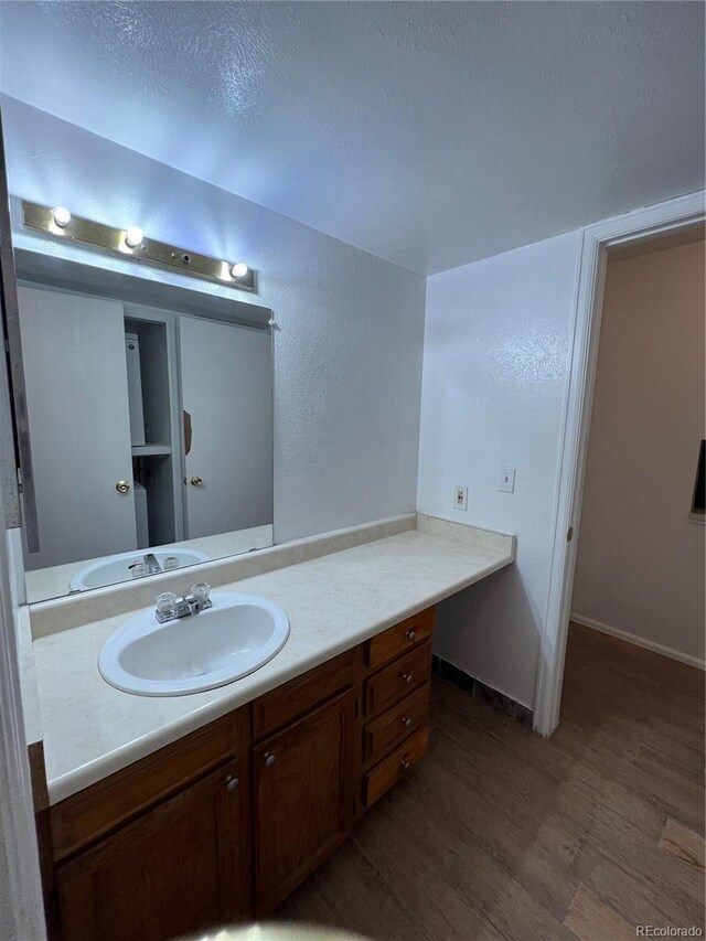 14852 E Kentucky Dr Unit 934, Aurora, CO 80012 - bathroom with wood finished floors, vanity, and a textured ceiling