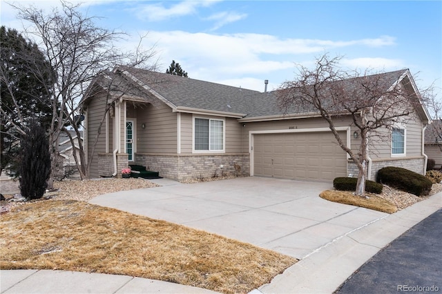 view of front of house featuring a garage, concrete driveway, a shingled roof, and brick siding