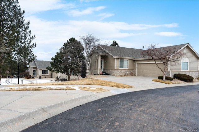 view of front of house with a garage, driveway, and stone siding