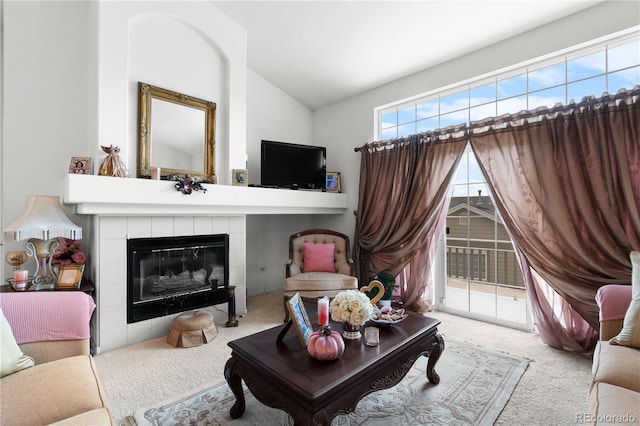 sitting room with light carpet, vaulted ceiling, and a tile fireplace