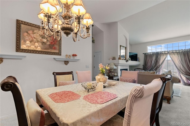 carpeted dining room with vaulted ceiling, a fireplace, and an inviting chandelier