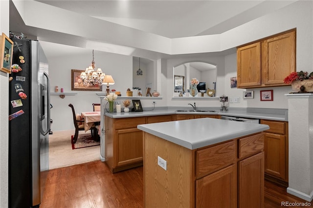 kitchen featuring brown cabinets, a center island, stainless steel appliances, light countertops, and pendant lighting