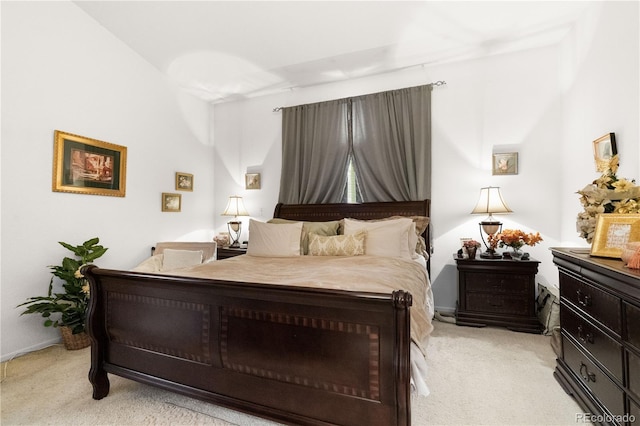 bedroom with light colored carpet and baseboards