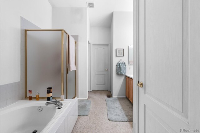 bathroom featuring a stall shower, visible vents, a garden tub, and vanity