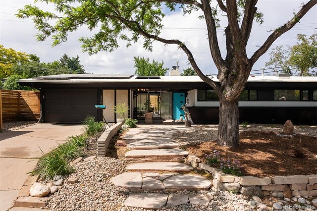 3605 W Berry Ave, Littleton, CO 80123 - view of front of home featuring solar panels, a chimney, and concrete driveway
