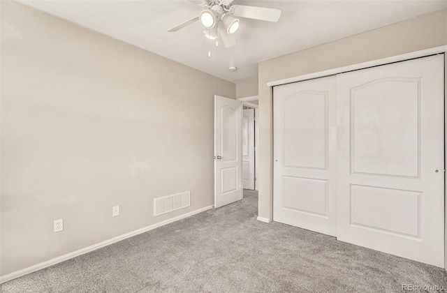 unfurnished bedroom featuring ceiling fan, light colored carpet, and a closet