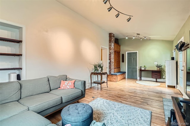 living room with rail lighting and light wood-style flooring