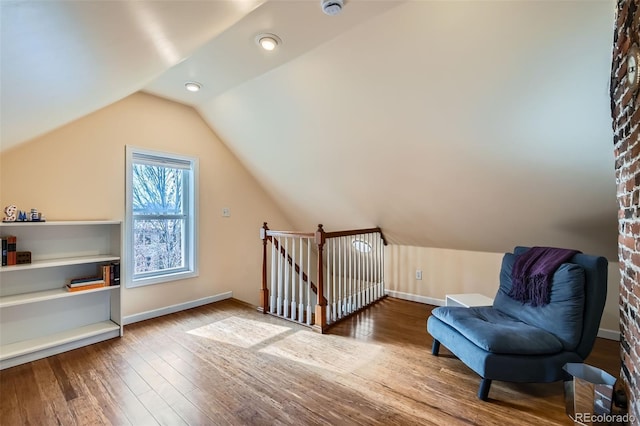 additional living space with lofted ceiling, hardwood / wood-style flooring, and baseboards