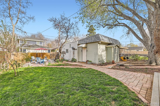 view of yard with an outdoor structure, fence, and a patio area