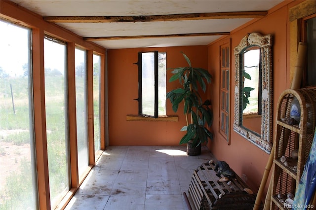 unfurnished sunroom with beamed ceiling