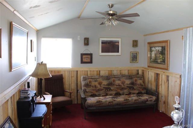 sitting room featuring dark colored carpet, ceiling fan, wood walls, and lofted ceiling