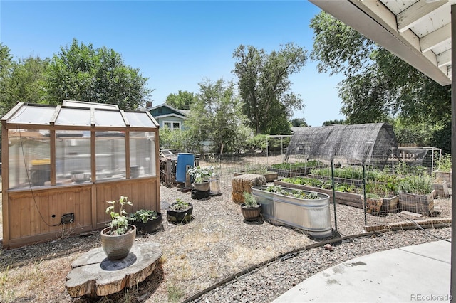 112 S Hooker St, Denver, CO 80219 - view of patio with a greenhouse, a vegetable garden, and an outbuilding