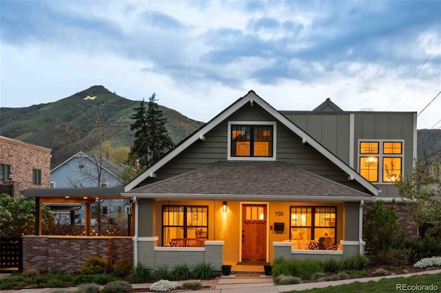 700 Cheyenne St, Golden, CO 80401 - craftsman-style home featuring brick siding, a shingled roof, board and batten siding, a porch, and a mountain view