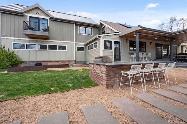 700 Cheyenne St, Golden, CO 80401 - rear view of house with outdoor dry bar, board and batten siding, a patio area, a yard, and metal roof