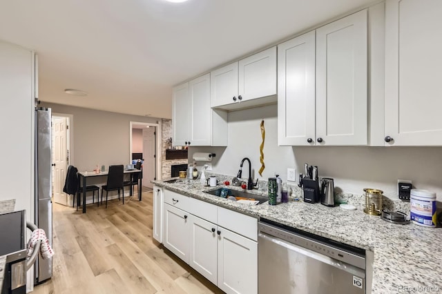 15047 E Louisiana Dr Unit A, Aurora, CO 80012 - kitchen with stainless steel appliances, white cabinets, light wood-type flooring, and light stone counters