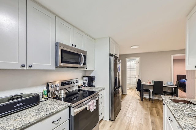 15047 E Louisiana Dr Unit A, Aurora, CO 80012 - kitchen with stainless steel appliances, white cabinetry, light wood finished floors, and light stone counters