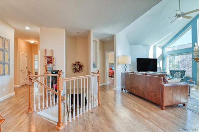 living room featuring ceiling fan, light hardwood / wood-style flooring, and lofted ceiling