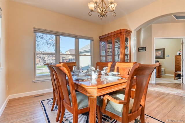 dining room with a notable chandelier and light hardwood / wood-style floors