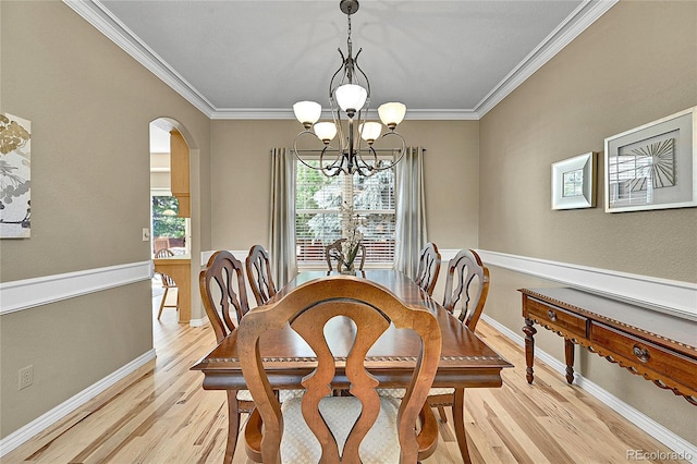 14878 E Aberdeen Ave, Centennial, CO 80016 - dining room featuring arched walkways, light wood-type flooring, a chandelier, ornamental molding, and baseboards