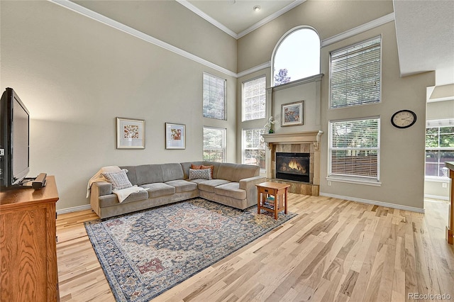 14878 E Aberdeen Ave, Centennial, CO 80016 - living area with baseboards, a tile fireplace, light wood finished floors, ornamental molding, and a high ceiling